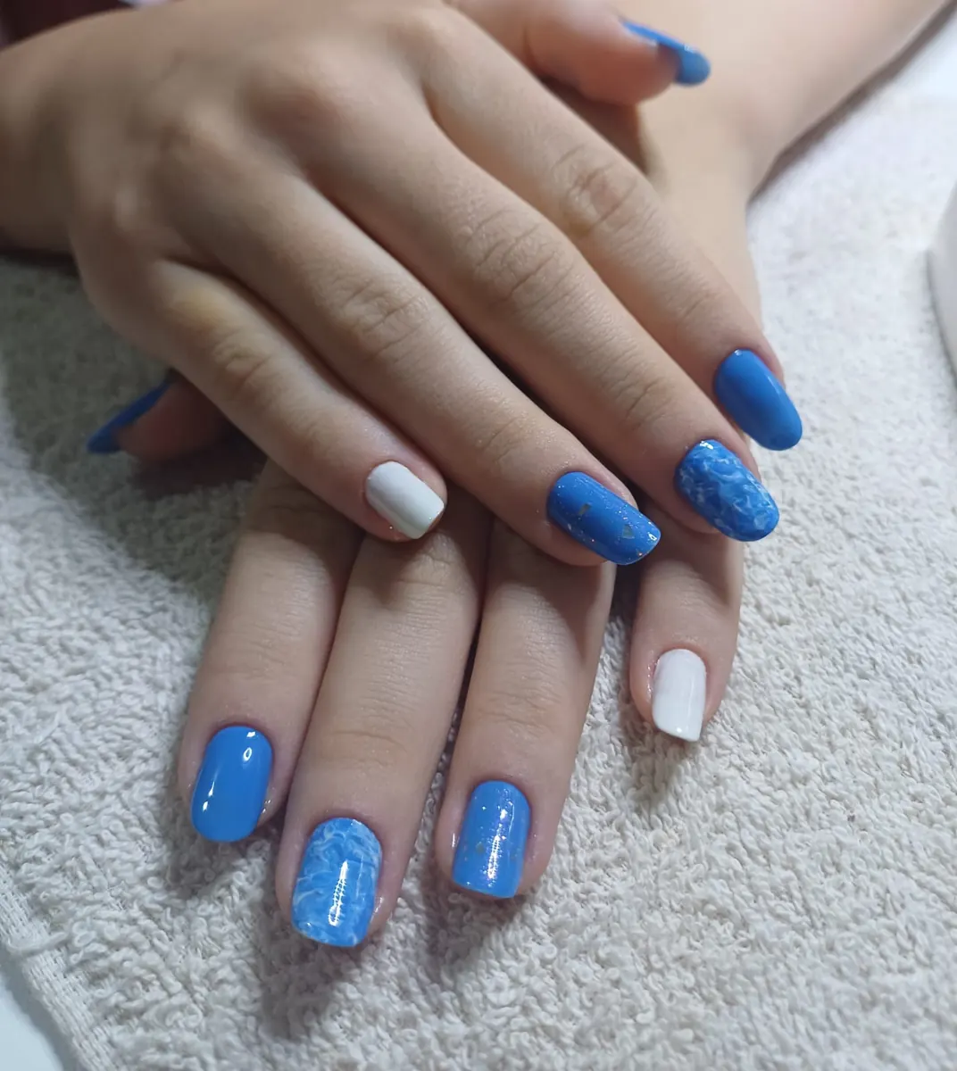 Unhas decoradas azul e branco com efeito marmorizado e flocos